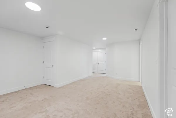 Plush carpeting throughout, neutral wall tones, recessed lighting, and white panel doors