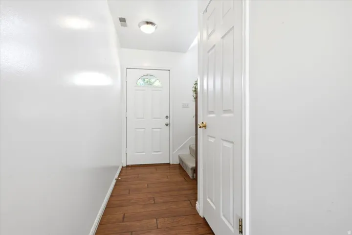 Entryway featuring wood-finish flooring, a paneled door with an arched window, and a flush mount ceiling light
