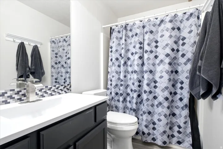 Bathroom vanity with a rectangular basin, white countertop, and dark cabinetry