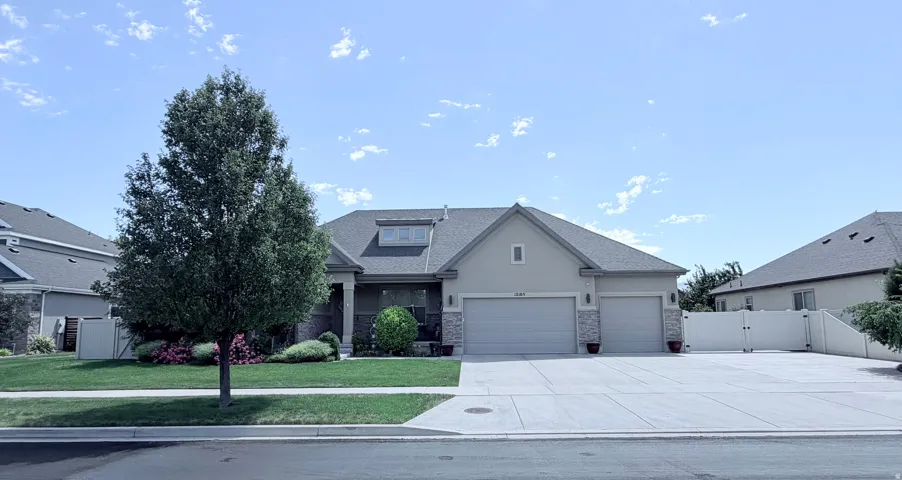Single-story residence featuring a stucco exterior with stone accents and a multi-car driveway