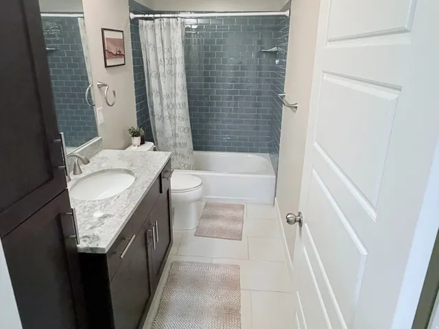 Bathroom featuring a dark wood vanity with a white countertop, undermount sink, and polished chrome faucet