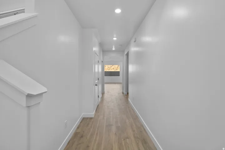 Entryway featuring wood-finish flooring, recessed lighting, white trim, and a staircase with white balustrade