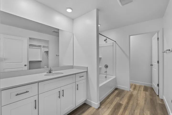 Bathroom featuring a spacious vanity with white cabinetry and a light-toned countertop