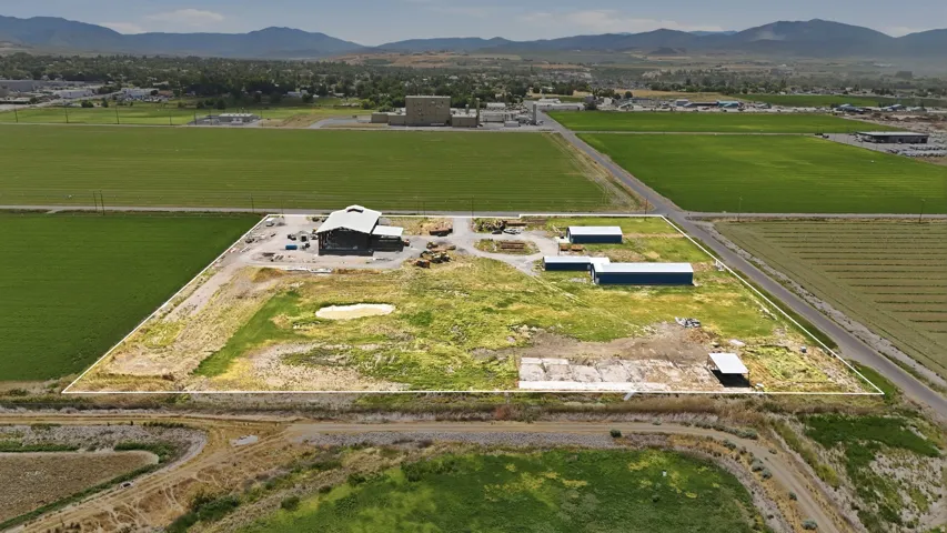 Expansive land parcel featuring multiple outbuildings and a main structure with a light-colored roof
