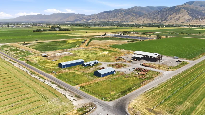 Expansive rural property featuring multiple outbuildings, agricultural fields, and a prominent mountain backdrop