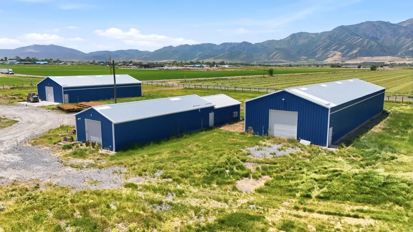 Multiple metal-sided structures featuring blue exteriors and silver corrugated roofs