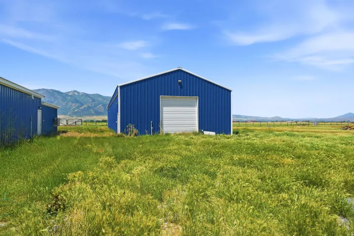 Blue metal building with a white roll-up garage door