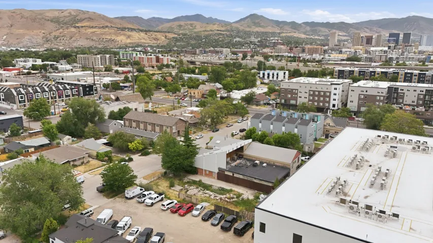 Urban landscape featuring a mix of residential and commercial buildings with a mountain backdrop