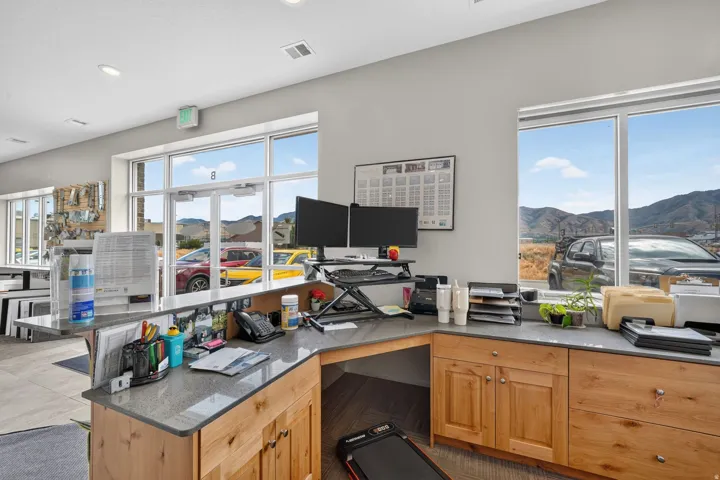 Spacious reception area featuring a wraparound counter with stone-finish surfacing and ample wood cabinetry