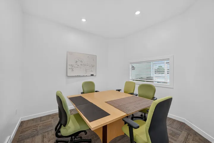 Dedicated room featuring a light-toned wood-finish table, recessed lighting, and a window with horizontal blinds