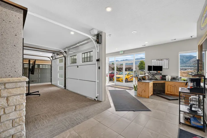 Versatile interior space featuring two overhead doors, recessed lighting, and a stone-clad column