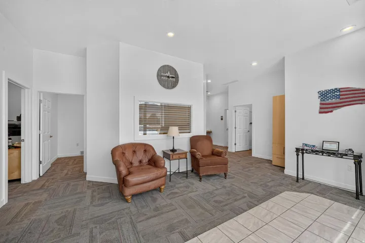 Spacious interior with recessed lighting, white walls, and a window with horizontal blinds
