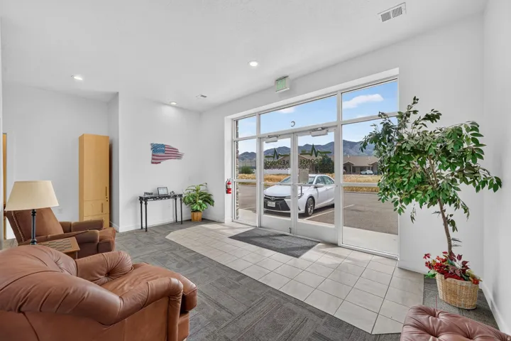 Entryway featuring expansive glass doors, tiled flooring, recessed lighting, and a neutral color palette