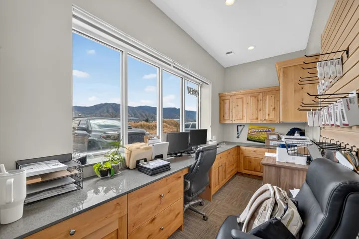 Office space featuring floor-to-ceiling windows, custom wood cabinetry, and solid surface countertops
