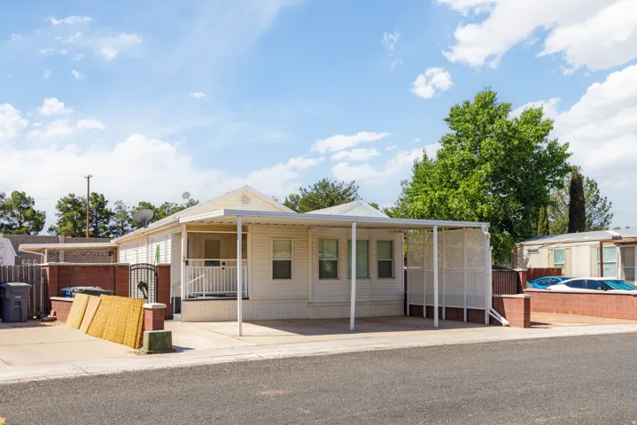 White siding exterior with a covered porch and an extended carport