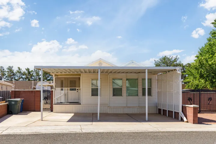 Single-story residence featuring light-colored siding and a covered carport