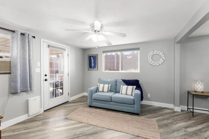 Room featuring wood-finish flooring in a chevron pattern, light gray walls, and a ceiling fan