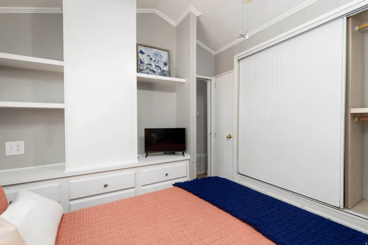 Built-in storage solutions featuring open shelving, base cabinets with drawers, and a dedicated media niche