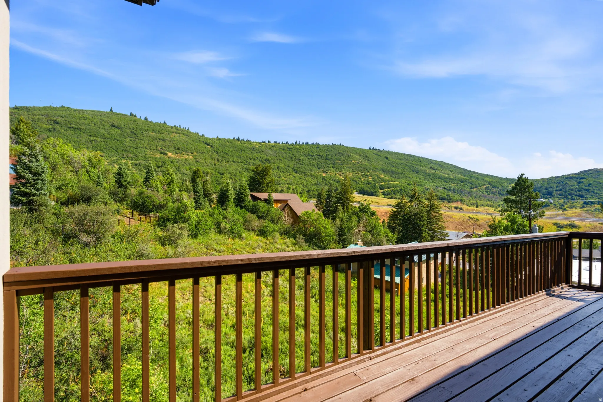 Expansive outdoor deck with wood-finish flooring and a wood railing system