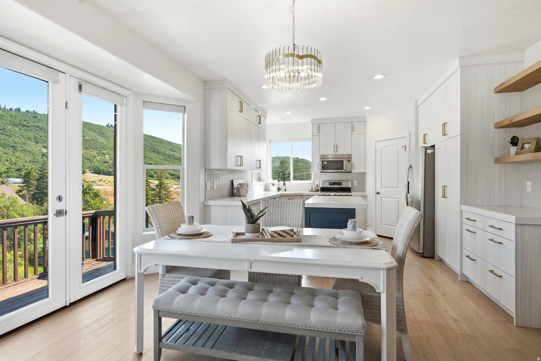 Bright kitchen with white cabinetry, stainless steel appliances, and a central island with a blue base