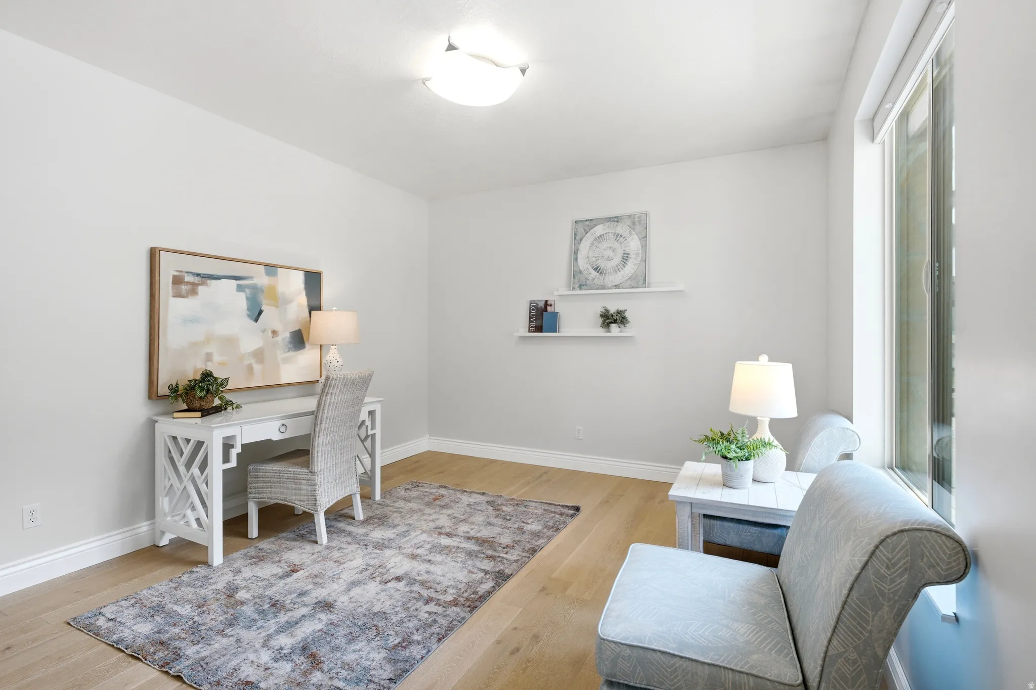 Bright interior room featuring wood-finish flooring, white baseboards, and neutral wall paint