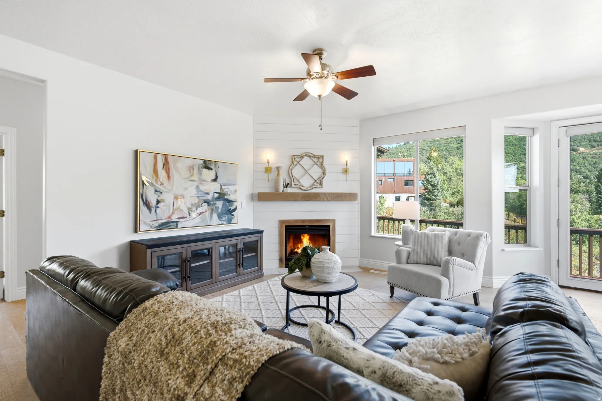 Living area featuring a fireplace with a wood mantle, shiplap surround, and wall sconces