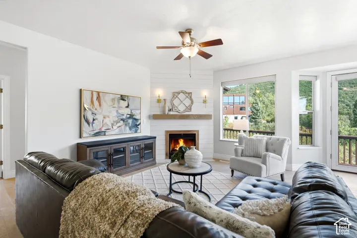 Living area featuring a fireplace with a wood mantle, shiplap surround, and wall sconces