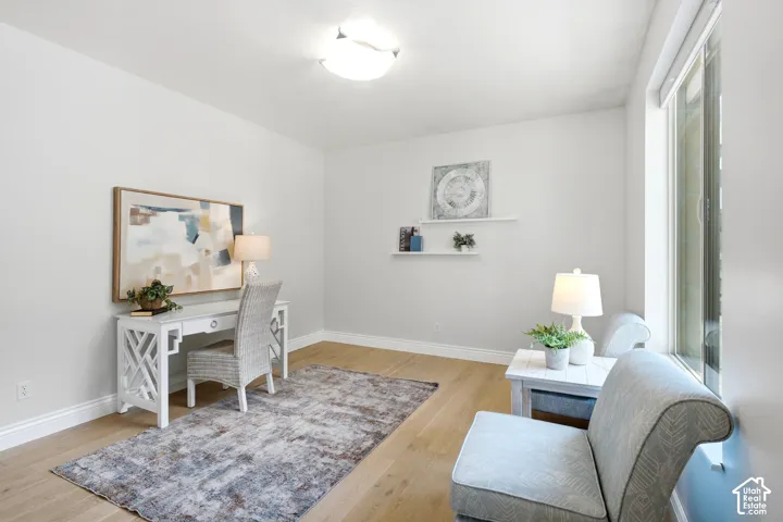 Bright interior room featuring wood-finish flooring, white baseboards, and neutral wall paint