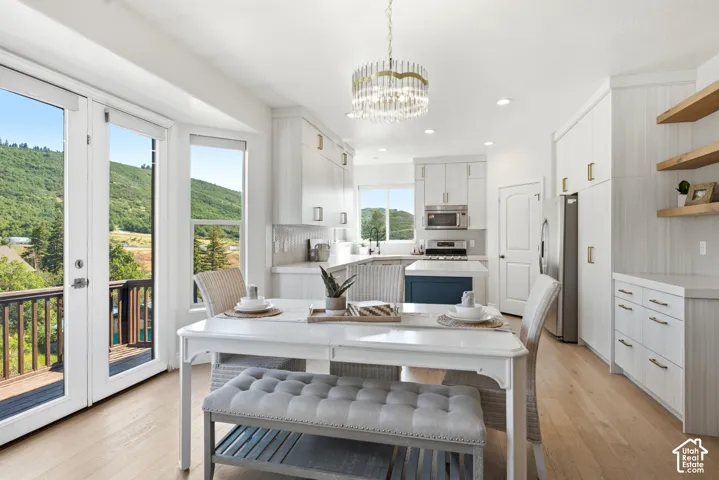 Bright kitchen with white cabinetry, stainless steel appliances, and a central island with a blue base