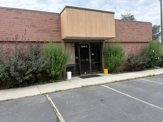 Brick exterior featuring a recessed entry with a wood-finish overhang and large glass doors