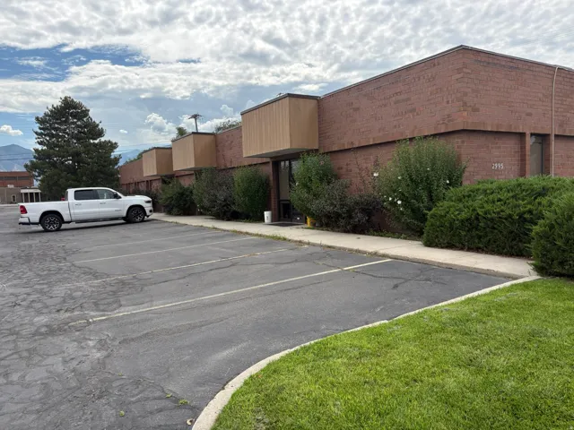Brick commercial building with wood-finish fascia accents and multiple entryways