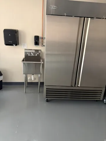 Stainless steel commercial refrigerator with dual doors and caster wheels