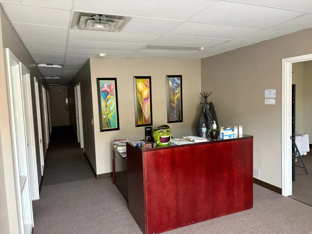 Reception area featuring a wood-finish desk, drop ceiling with recessed lighting, and neutral wall paint