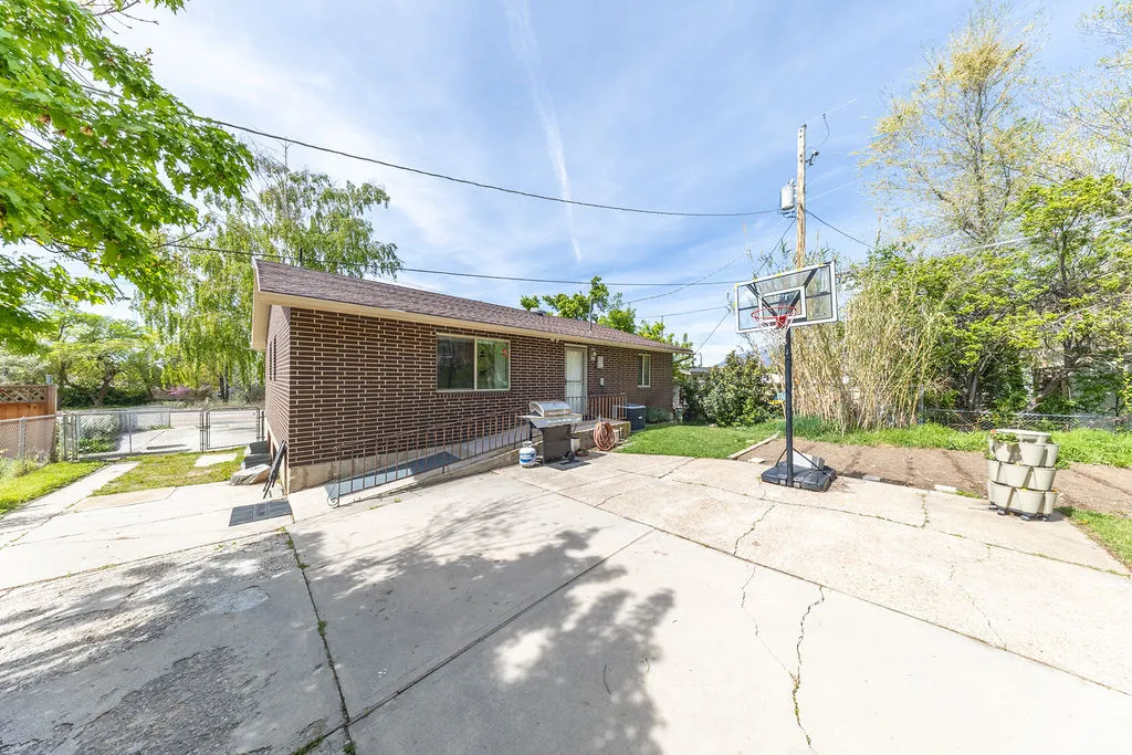 Brick exterior featuring a concrete driveway and adjacent lawn area
