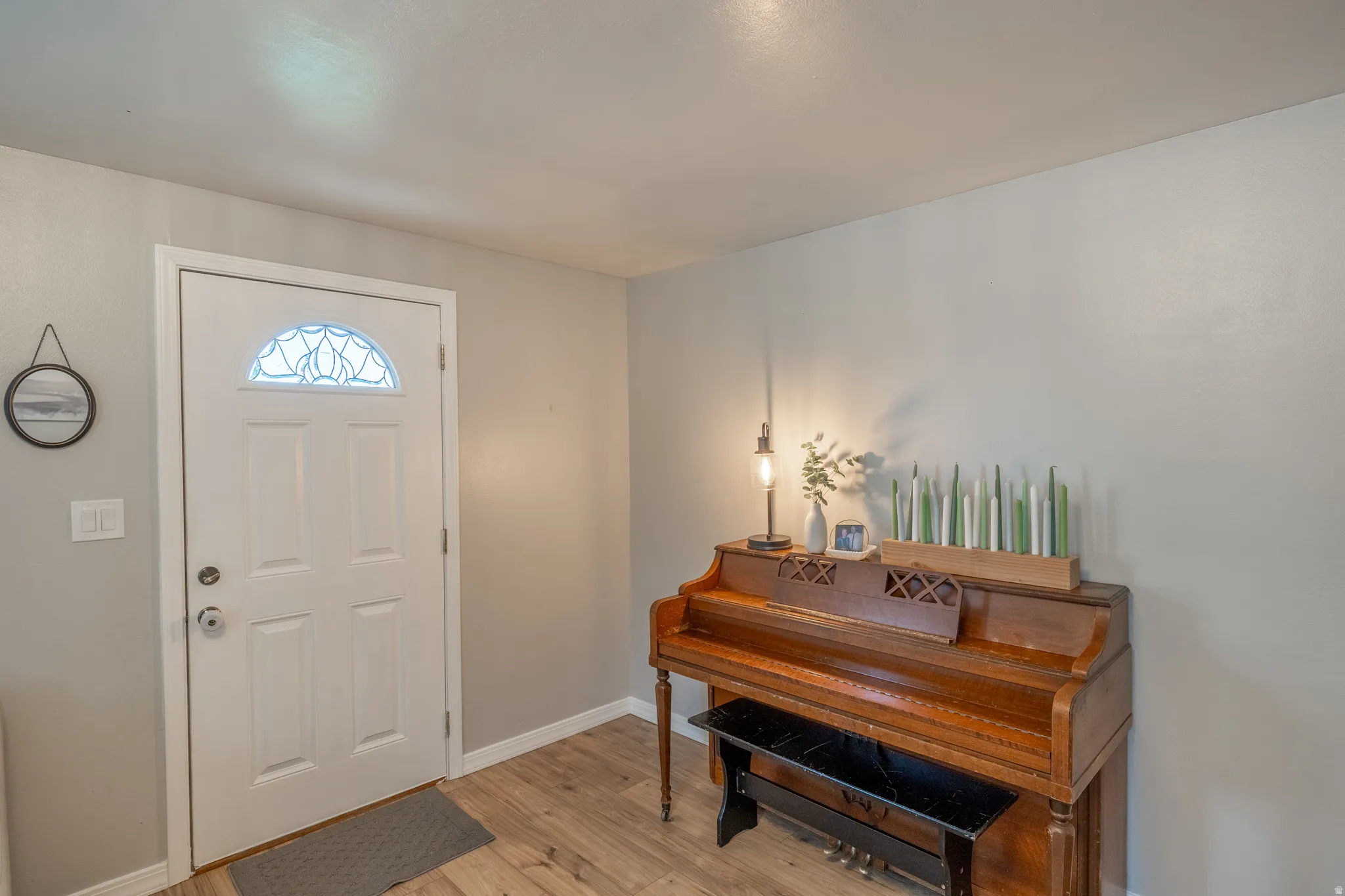 Entryway featuring a white paneled door with an arched decorative glass insert and brushed nickel hardware