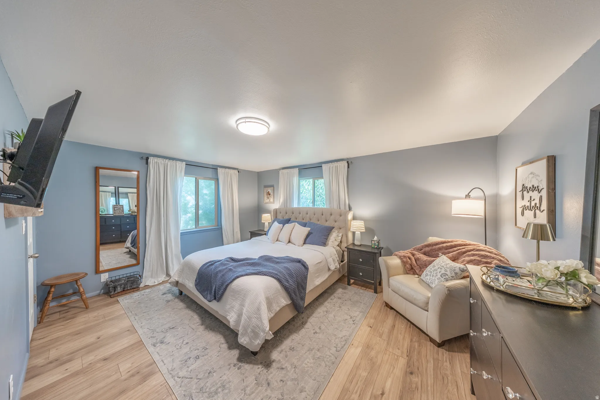 Spacious room featuring wood-finish flooring and light blue walls