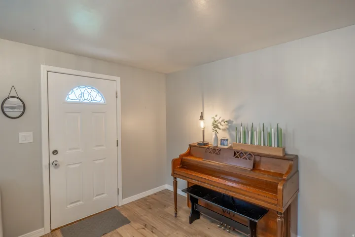 Entryway featuring a white paneled door with an arched decorative glass insert and brushed nickel hardware
