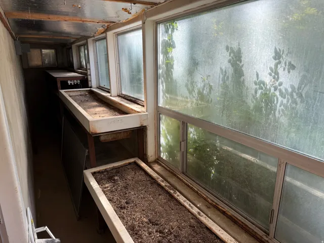 Greenhouse  featuring multiple window units, built-in planters, and a metal ceiling