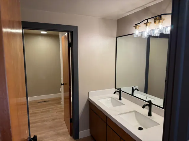 Dual vanity with integrated sinks, matte black faucets, and a light-toned countertop