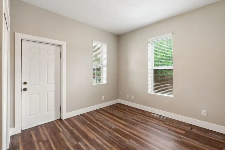 East unit - Bedroom #2. Neutral wall tones complement wood-finish flooring