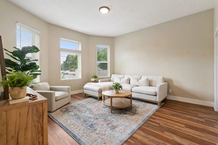 West unit. Living area featuring multiple windows, wood-finish flooring, neutral wall tones, and a built-in ceiling light fixture