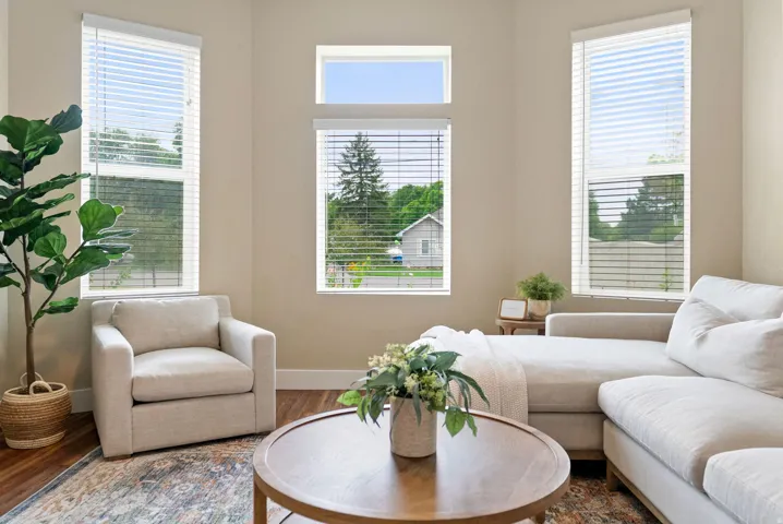 West unit. Bright living space featuring multiple tall windows with blinds and a transom window