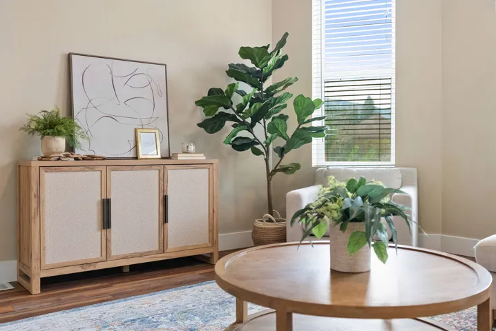West unit. Window with horizontal blinds, light beige wall paint, wood-finish flooring, and white baseboards