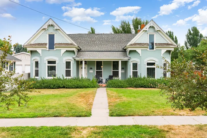 Victorian-style residence with a light blue exterior, gabled rooflines, and decorative trim
