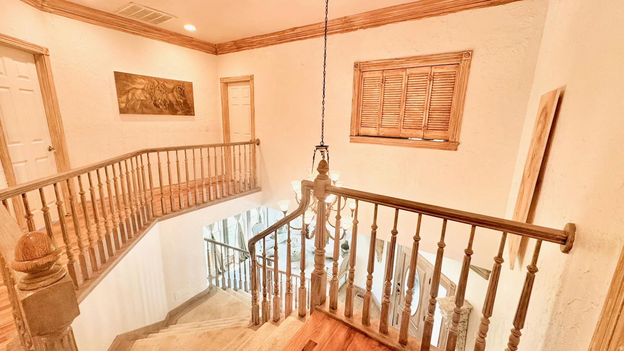 Multi-level staircase featuring light wood-finish flooring, wood balusters, and a matching wood handrail