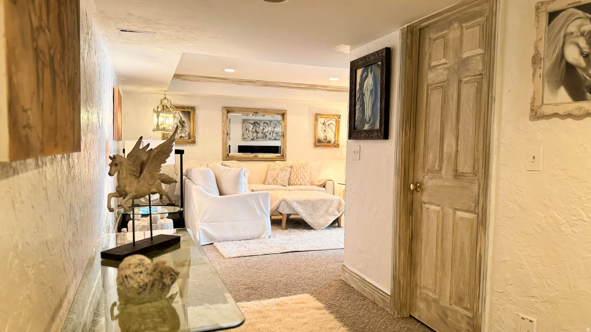 Carpeted interior area with textured walls and a paneled wooden door