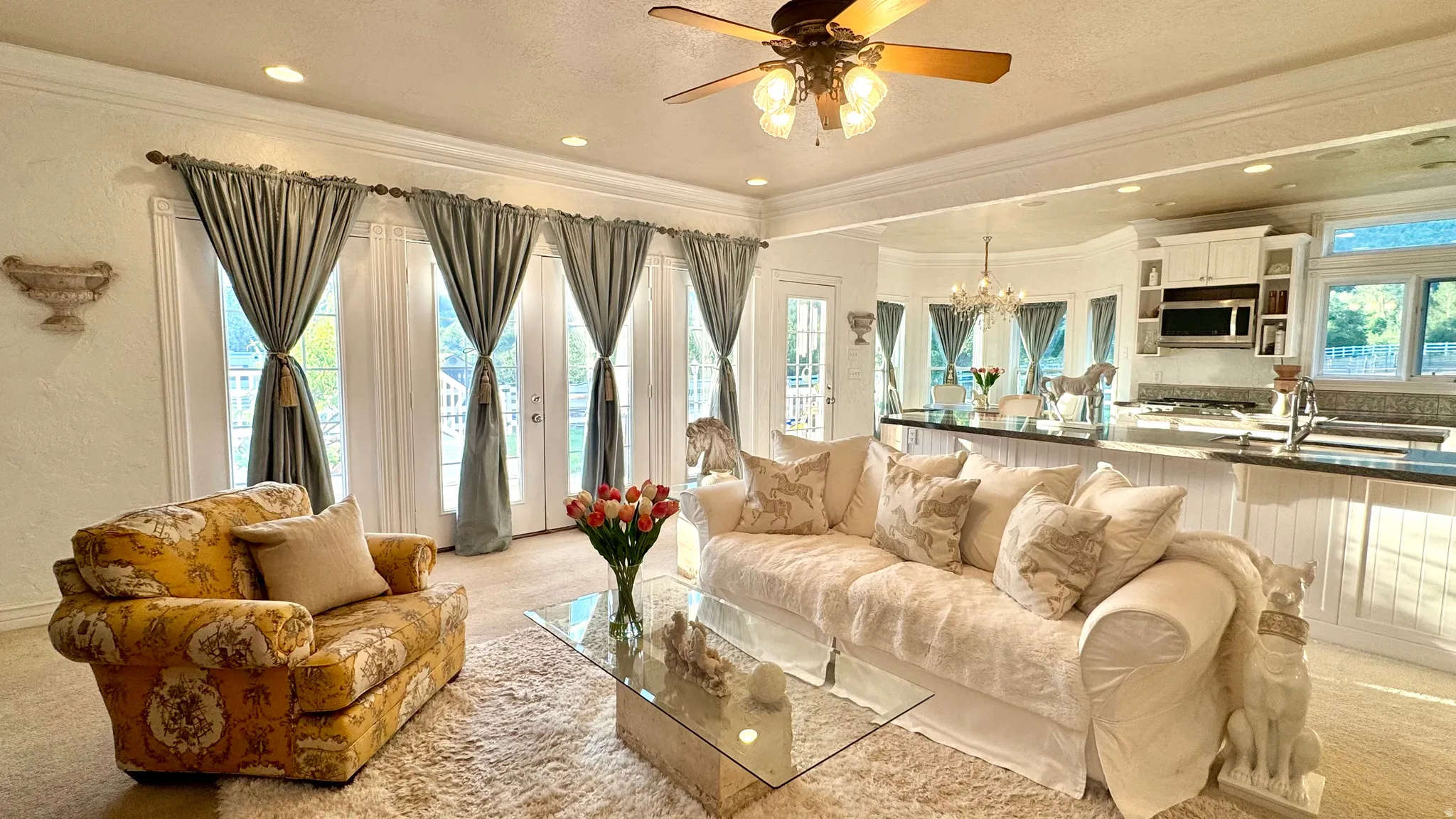 Open-concept living space featuring multiple French doors, recessed lighting, and a ceiling fan