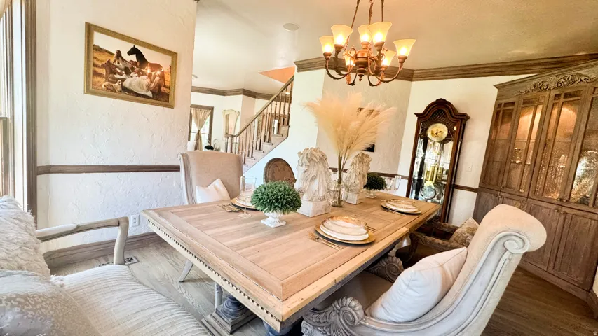 Formal dining area featuring a wood-finish table, chandelier lighting, and hardwood flooring