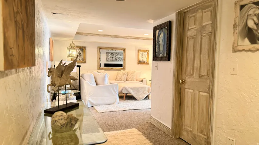 Carpeted interior area with textured walls and a paneled wooden door