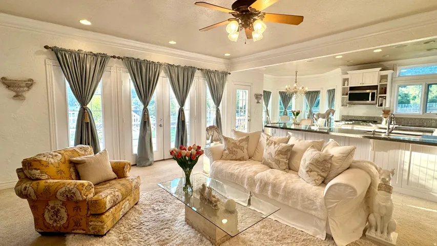 Open-concept living space featuring multiple French doors, recessed lighting, and a ceiling fan